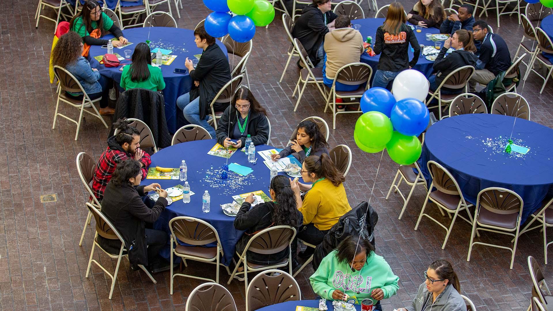 Students gathered at blue and green tables